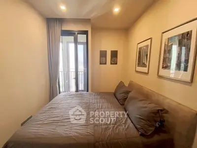 Cozy bedroom with modern decor and balcony access in a stylish apartment.