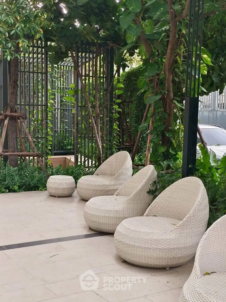 Chic outdoor seating area with modern wicker chairs and lush greenery