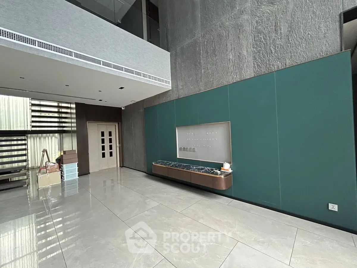 Luxurious modern building entrance with sleek design and high ceilings.