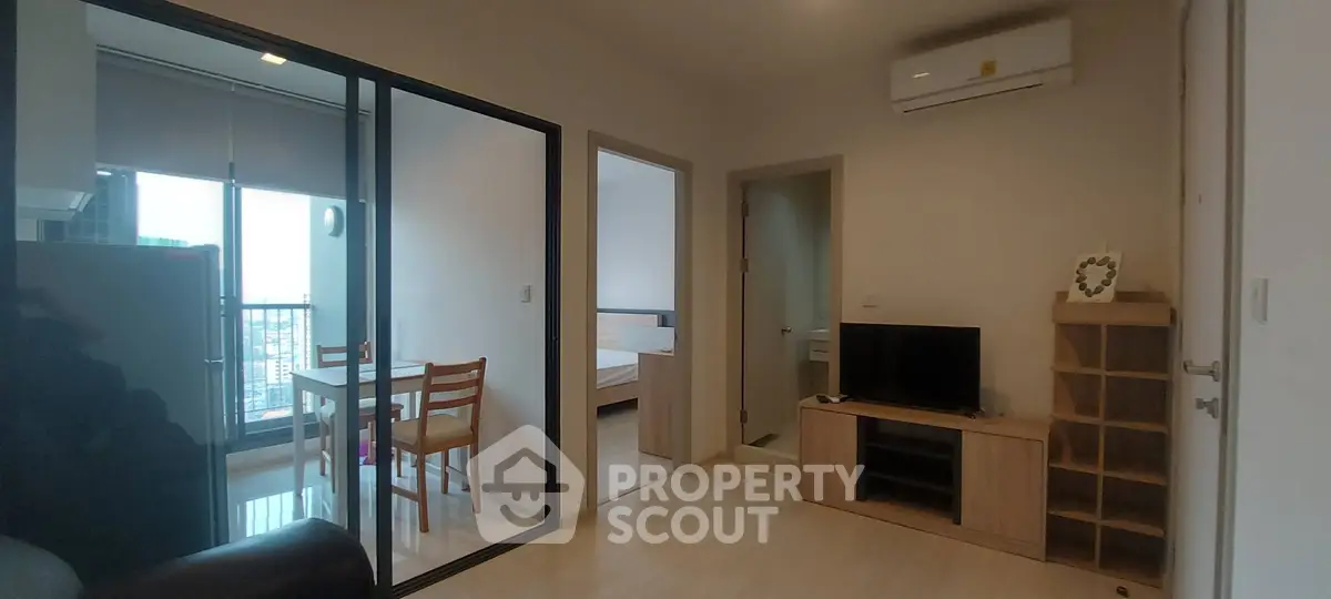 Modern apartment interior with open living room and dining area, featuring air conditioning and natural light.