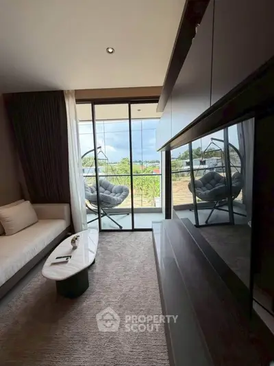 Modern living room with balcony view and stylish furniture in a cozy apartment.