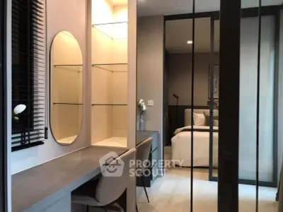Modern bedroom with stylish vanity and glass partition, featuring elegant decor and cozy ambiance.