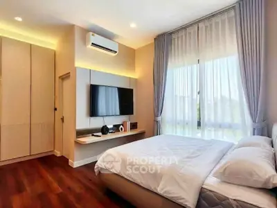 Modern bedroom with large window, stylish decor, and wooden flooring