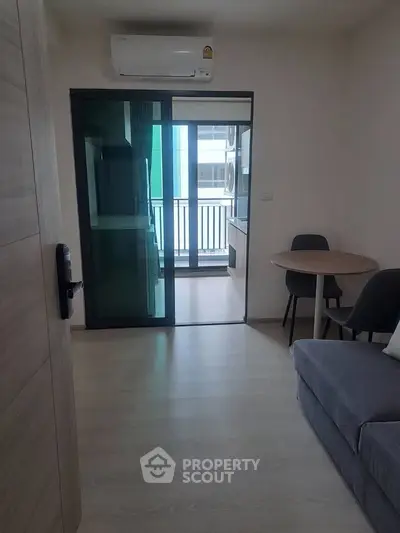 Modern apartment living room with balcony access and sleek furnishings.