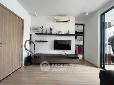 Modern living room with sleek TV unit and air conditioning in a stylish apartment.