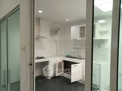 Modern kitchen with sleek white cabinets and built-in gas stove, perfect for culinary enthusiasts.