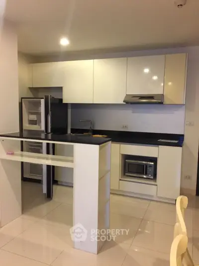 Modern kitchen with sleek cabinetry and built-in appliances in a compact layout.