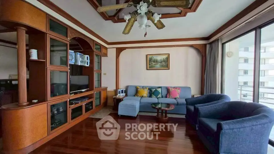 Spacious living room with elegant wooden decor and large windows for natural light.