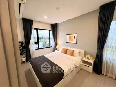 Modern bedroom with large window and stylish decor in a cozy apartment.