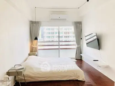 Bright and airy bedroom with modern decor and large window view.