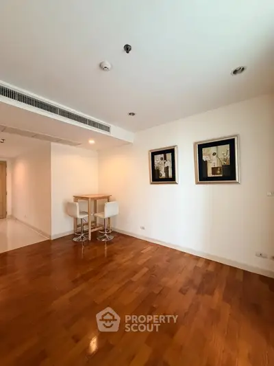 Spacious living room with wooden flooring and modern decor in a stylish apartment.