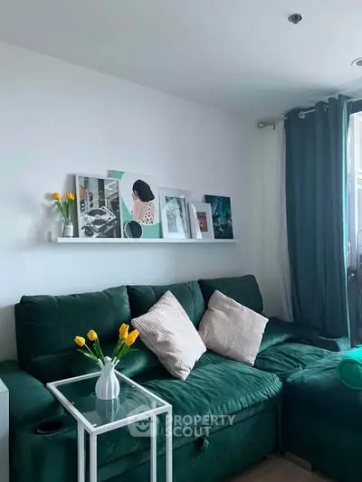 Stylish living room with green sofa, modern decor, and natural light