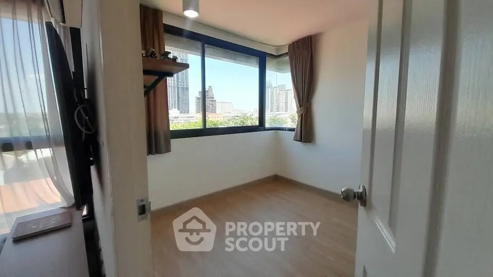 Bright empty room with large windows offering city views, perfect for customization.