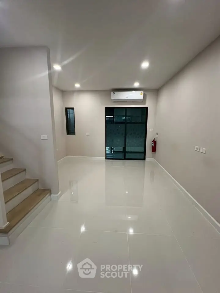 Spacious modern living room with sleek tile flooring and staircase