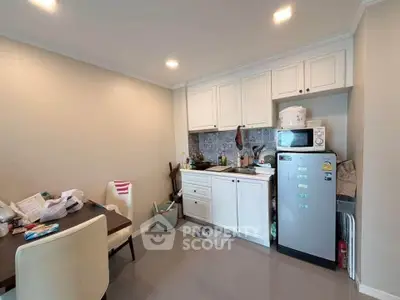 Cozy kitchen with white cabinets and modern appliances in a compact dining area.
