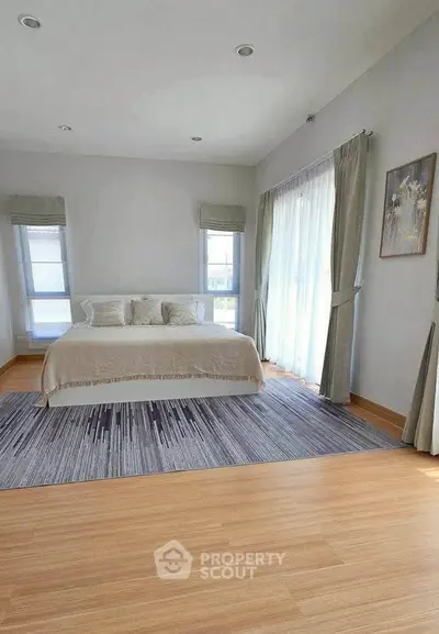 Spacious bedroom with large windows and elegant decor