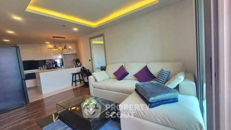 Modern living room with cozy sofa and stylish kitchen in open layout apartment.
