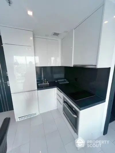 Modern kitchen with sleek white cabinetry and black countertops