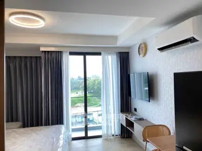 Modern bedroom with balcony view, featuring sleek furniture and natural light.
