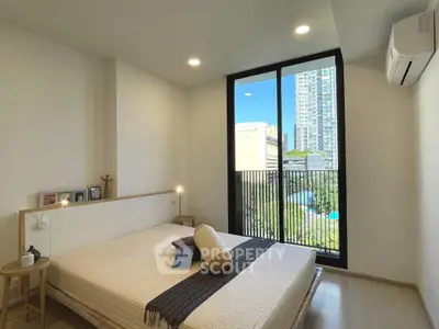 Modern bedroom with large window and city view, featuring minimalist decor and natural light.