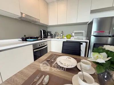 Modern kitchen with sleek cabinetry, built-in oven, and dining setup for a cozy meal.