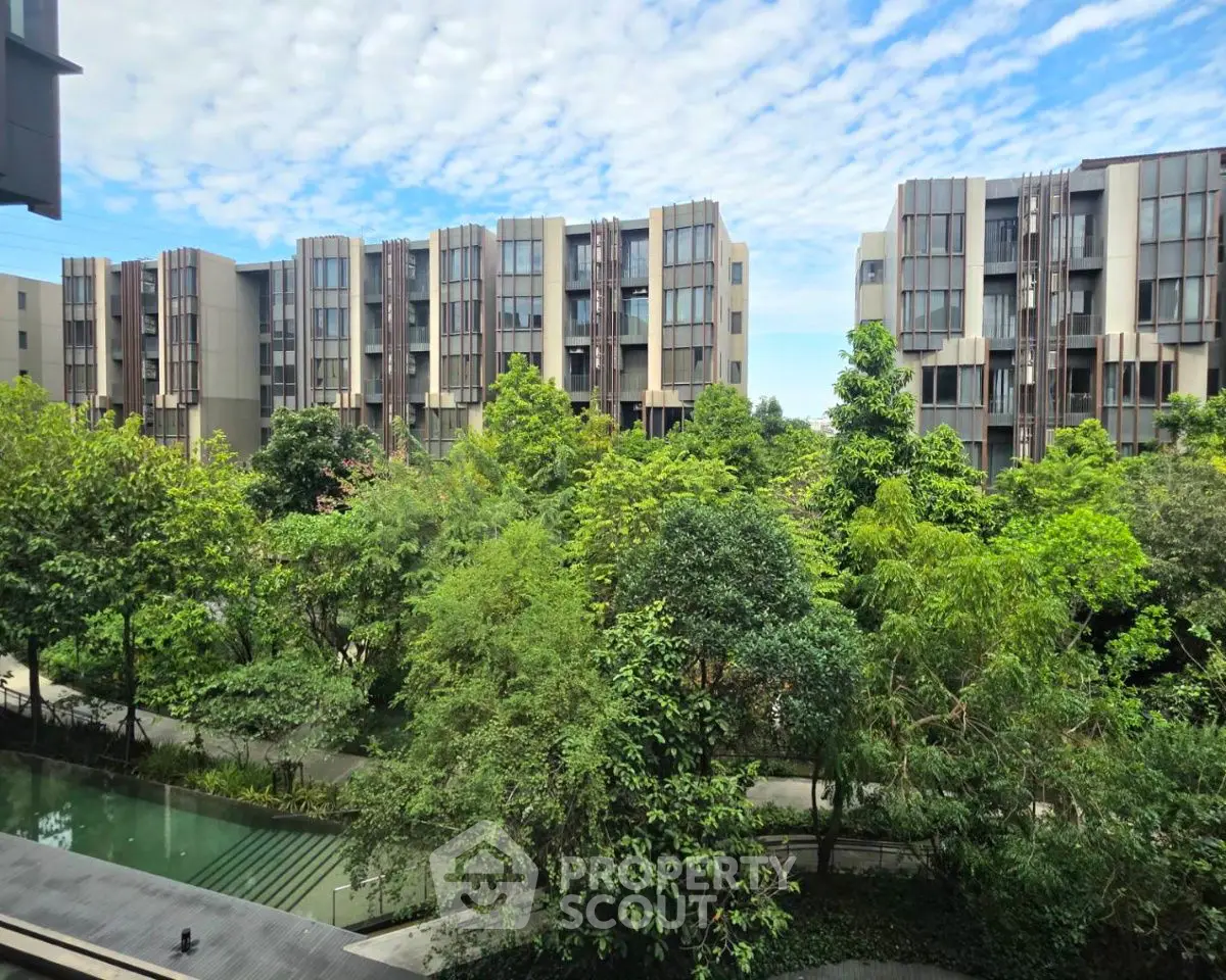 Modern residential buildings with lush green garden and clear blue sky view.