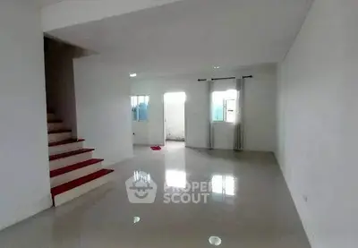 Spacious unfurnished living room with glossy tiled floors and staircase