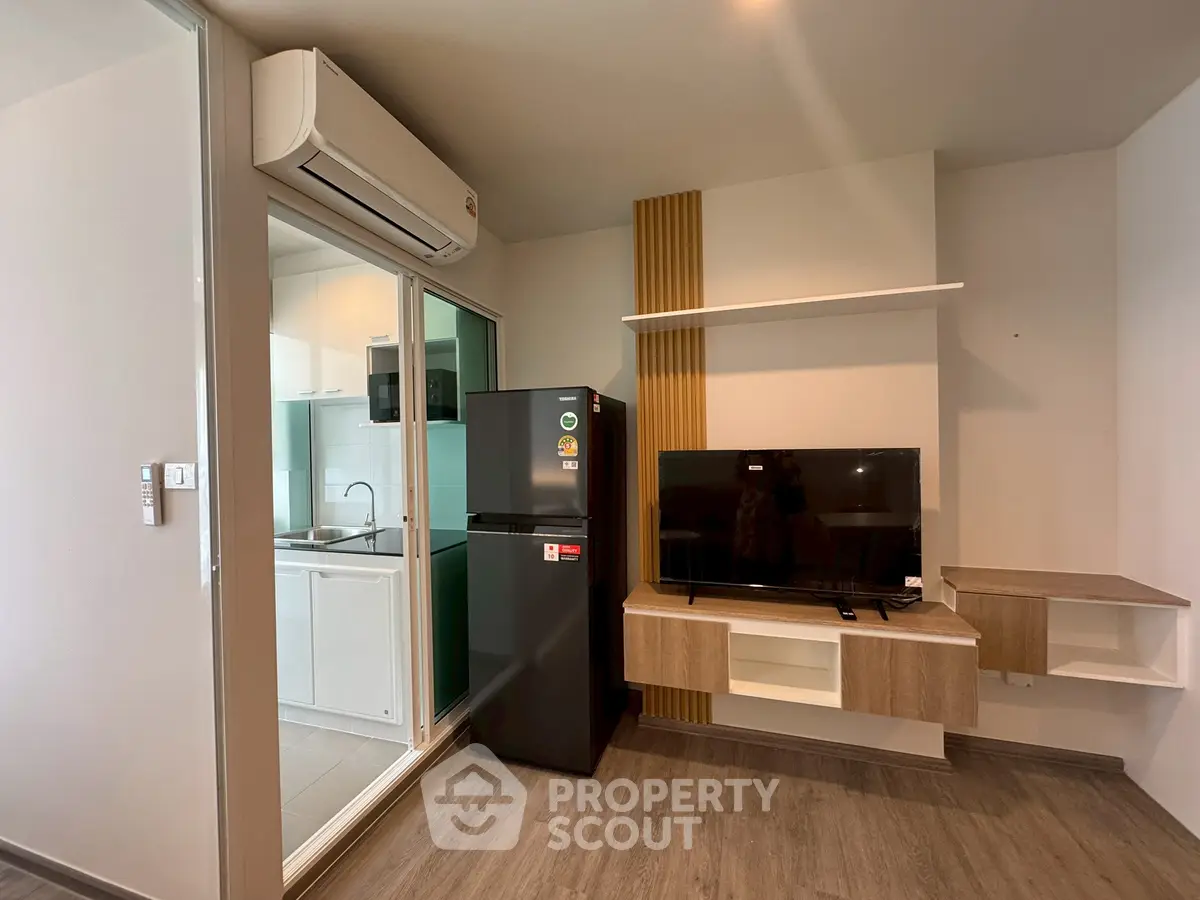Modern apartment interior with open kitchen and living area featuring sleek appliances.