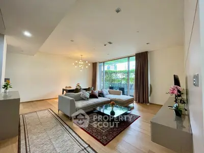 Spacious modern living room with elegant decor and large windows opening to a lush balcony view.