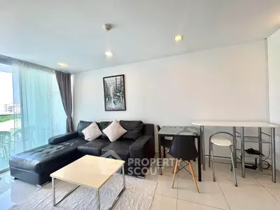 Modern living room with black leather sofa and chic decor in a bright apartment.
