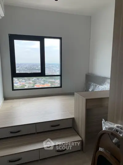 Modern bedroom with elevated platform and panoramic city view from large window.