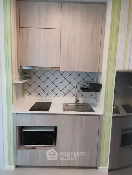 Modern compact kitchen with sleek cabinetry and built-in appliances, perfect for urban living.
