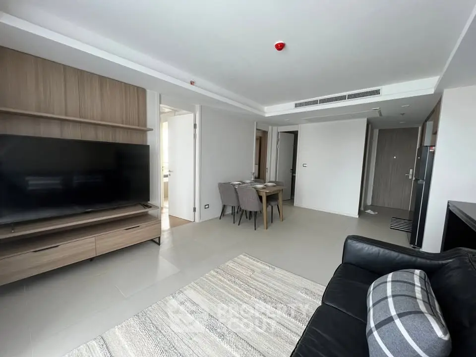 Modern living room with sleek furniture and large TV in a stylish apartment.