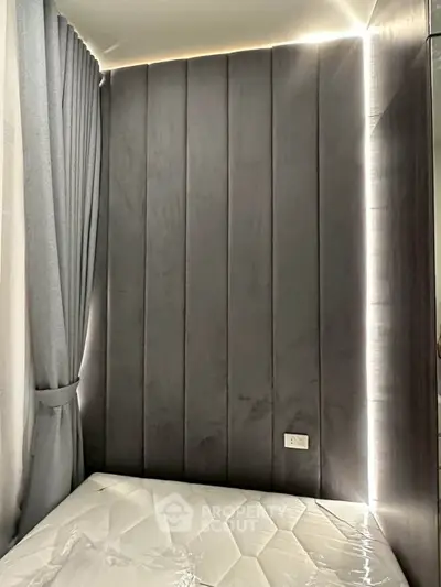 Modern bedroom with sleek panel wall and ambient lighting