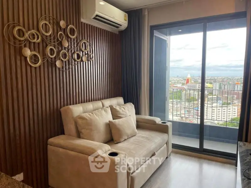 Modern living room with cozy sofa and city view from balcony, featuring stylish wall decor and air conditioning.