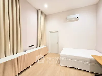 Spacious bedroom with minimalist decor, featuring a comfortable bed and elegant curtains, perfect for relaxation.
