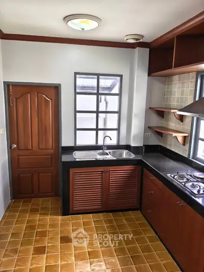 Charming kitchen with gas stove and wooden cabinetry, perfect for culinary enthusiasts.