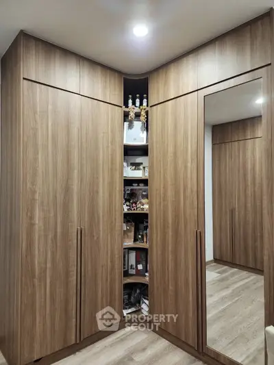 Spacious corner wardrobe with mirrored door in modern bedroom