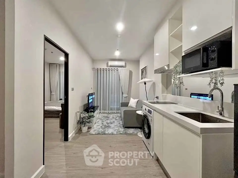 Modern open-plan living room and kitchen with sleek design and washing machine