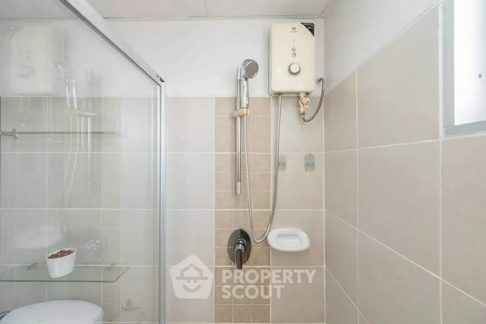 Modern bathroom with shower and water heater in a minimalist design.