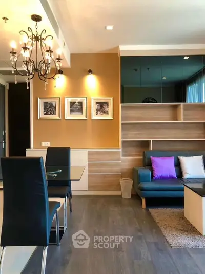 Modern living room with elegant chandelier and stylish furniture in a cozy apartment.