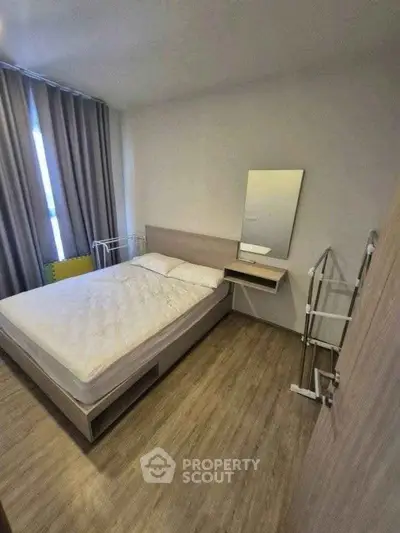 Cozy bedroom with modern decor and natural light, perfect for relaxation.