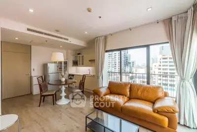 Spacious modern living room with leather sofa and city view balcony in luxury apartment.
