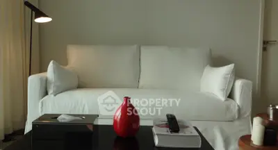 Elegant living room with white sofa, modern decor, and ambient lighting.