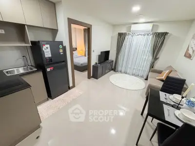 Modern open-plan living room with kitchen and dining area in stylish apartment.