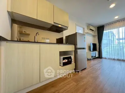 Modern open-layout kitchen with sleek cabinets and appliances in a bright living space.