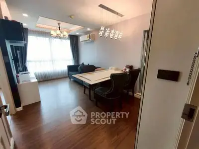Spacious living room with elegant dining area and large window for natural light.