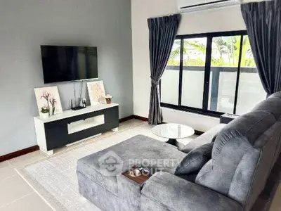 Modern living room with sleek furniture and large window offering natural light.