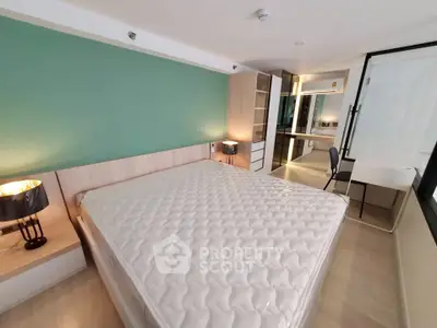 Modern bedroom with stylish decor and ample natural light, featuring a comfortable bed and functional workspace.