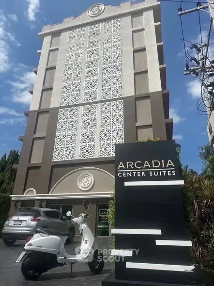 Modern building exterior of Arcadia Center Suites with stylish facade and parked scooter.